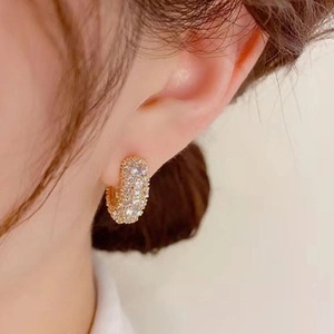 Elegant gold-plated C-shaped hoop earrings with micro-pave cubic zirconia on female ear