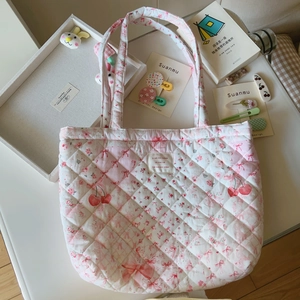Detail der gesteppten Baumwolltasche in Rosa mit Kirsch- und Schleifenmuster