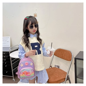 Girl wearing a purple mermaid backpack with seashell and starfish 3D decorations