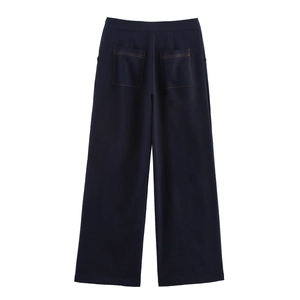 Detail of dark blue wide-leg trousers showing back pockets and contrast stitching accents