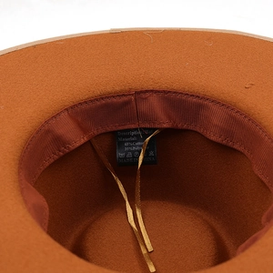 Detail view of wide brim wool fedora inner lining with adjustable strap and care label