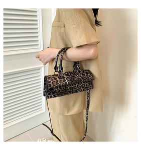 Detailed view of leopard print crossbody bag with dual handles and adjustable strap