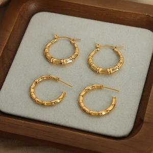 Bamboo-style gold plated stainless steel hoop and C-shape earrings set on a display tray