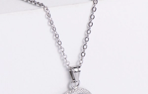 Vue macro d'un pendentif zodiaque en titane argenté avec texture fine et chaîne délicate