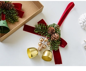 Detailed Christmas hanging ornament with red velvet bow, pine cones, and gold bells