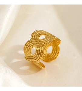 Detailed close-up of gold stainless steel ring with woven wave texture on satin