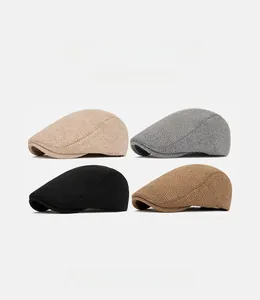 Vue à plat de quatre casquettes vintage en beige, gris, noir et marron chaud