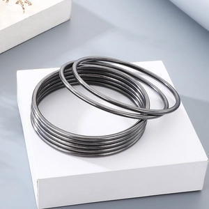 Stackable gunmetal grey 3mm stainless steel round bangles set on a display stand