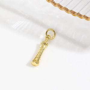 Detailed macro view of 18k gold plated copper tower pendant with ornate carvings
