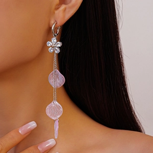Detail of silver drop earring featuring sparkling gemstone flower and purple resin petals
