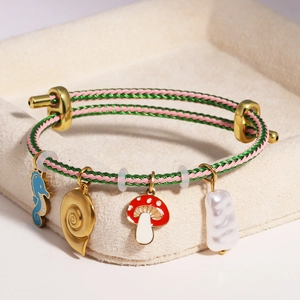 Detail of adjustable woven bracelet with seahorse, shell, mushroom and pearl charms