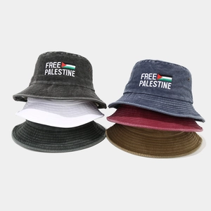 Dettaglio del ricamo Free Palestine su cappelli a secchiello in cotone lavato multicolore