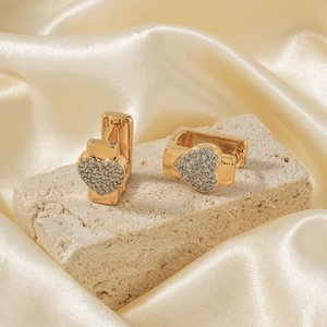 Exquisite gold heart-shaped hoop earrings with zircon pavé on a stone background