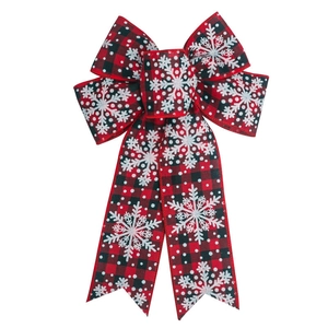 Detail of red and black buffalo plaid Christmas bow with white snowflake patterns