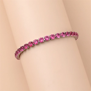 Close-up of pink round-cut tennis bracelet with silver-tone four-prong claw setting