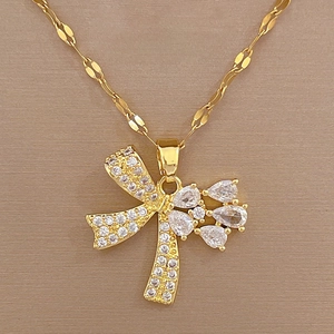 Detailed view of luxury gold butterfly pendant with teardrop zircons on silk background