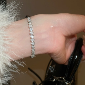 Détail du bracelet tennis en argent en forme de cœur avec pavé de pierres au poignet