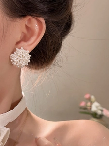 Detail shot of vintage pearl cluster earrings with elegant French retro floral design
