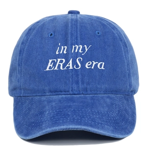 Close-up of in my ERAS era white embroidery on washed blue cotton baseball cap