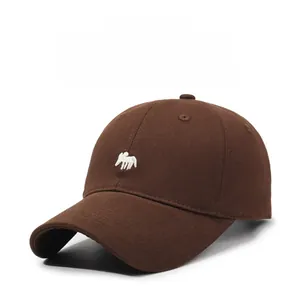 Detailed close-up of dark brown cotton baseball cap with white animal embroidery