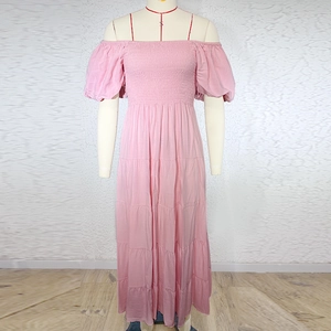 Detail of the pink off-shoulder maxi dress with elastic bust and tiered ruffle skirt