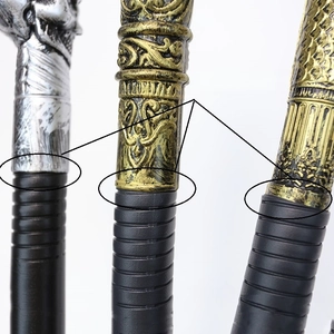 Detail view of metallic skull and antique gold cane toppers with engraved connector rings