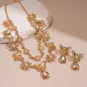 Detailed view of vintage gold floral and butterfly jewelry set with pearls and gems