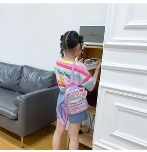 Detail of a purple transparent kids backpack with cat ears and sequin bow on a toddler