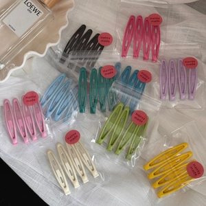 Detail of candy-colored metal bobby pins in a set of four with Hansy made brand packaging
