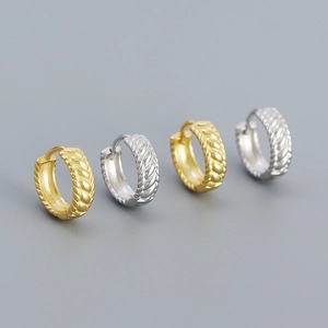 Macro detail showing twisted rope texture and S925 hallmark on gold and silver hoop earrings