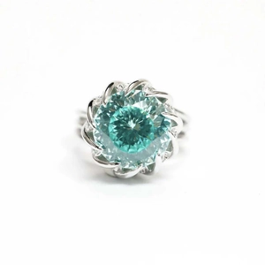 Macro shot of silver lotus ring featuring a large round teal gemstone and small diamonds