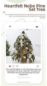 Mini tabletop flocked cedar Christmas tree with ornaments, pine cones, and lights