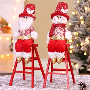 Detail of Santa and snowman plush sitting on red ladders for Christmas home decoration