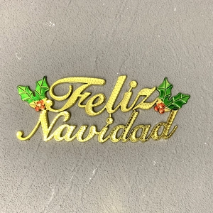 Golden Feliz Navidad Christmas ornament with green holly leaves and red berries on grey base