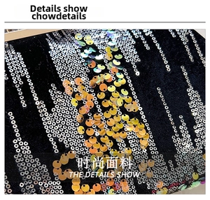 Close-up of sparkling gold and silver sequins on high-quality black fabric of an evening bag