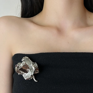 Elegant vintage silver rose flower brooch pinned on a black garment for women