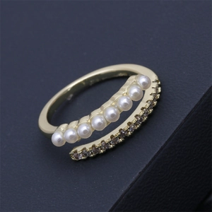 Détail macro d'une bague double rangée avec perles blanches et micro-pavage de pierres