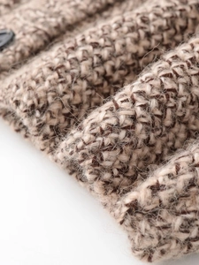 Macro shot of thick brown and beige knit fabric showing soft plush texture and detail
