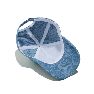 Detail view of denim sun hat showing blue floral print lining and adjustable metal buckle