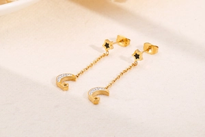 Detailed macro view of golden star and moon tassel earrings with sparkling rhinestones