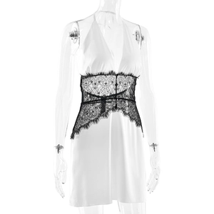 Dettaglio dell'abito in raso bianco con pizzo nero intrecciato e scollo all'americana