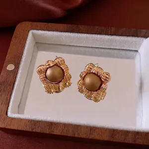 Quadratische Vintage-Ohrringe mit braunen Perlen auf Holz-Spiegelbox und Seide