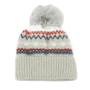 Detail of winter knit beanie showing gray fur pom-pom and classic snowflake pattern