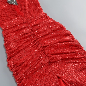 Detail of red sequin party dress showing intricate pleats and shiny fabric texture