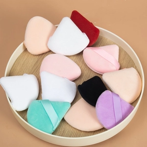 Set di 12 piumini da cipria triangolari multicolore in un vassoio di legno tondo