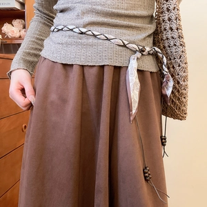 Détail d'une ceinture foulard en soie paisley avec perles en bois et finitions ethniques