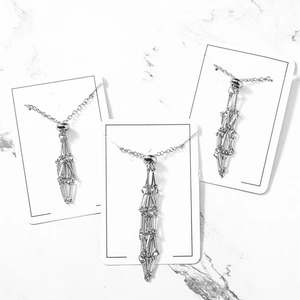 Three minimalist silver bamboo-style stainless steel cage necklaces with adjustable chains