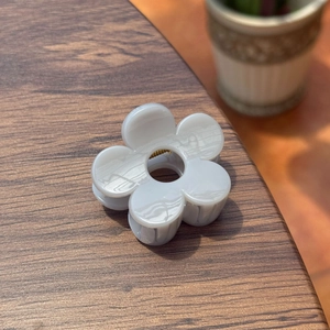Vue détaillée de la pince à cheveux en acrylique blanc en forme de fleur à cinq pétales