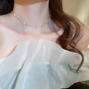 Detail of silver butterfly pendant necklace with sparkling rhinestones on model's neck