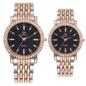 Détail de montres de couple à quartz or rose et argent avec lunettes en strass noir